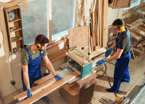 Empresa de carpintería en Málaga con taller propio Equipo de carpinteros cepillando madera en el taller propio de la C. Lanuza, Málaga