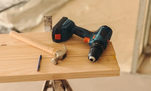 Herramienta profesional para el montaje de muebles Atornillador y martillo de carpintero sobre un tablero de madera durante un montaje de muebles