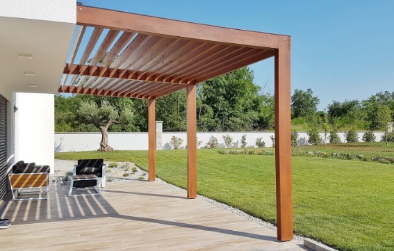 Carpintería exterior en Málaga Pérgola adosada a la fachada con techo de lamas de madera sobre una tarima de exterior
